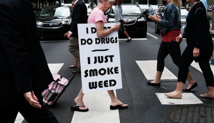 PHILADELPHIA, PA - JULY 28: A woman walks with a sign supporting the legalization of marijuana during the Democratic National Convention (DNC) on July 28, 2016 in Philadelphia, Pennsylvania.  The congress officially started on Monday and has drawn thousands of protesters, media representatives and democratic delegates to the city of brotherly love.  (Photo by Spencer Platt / Getty Images)