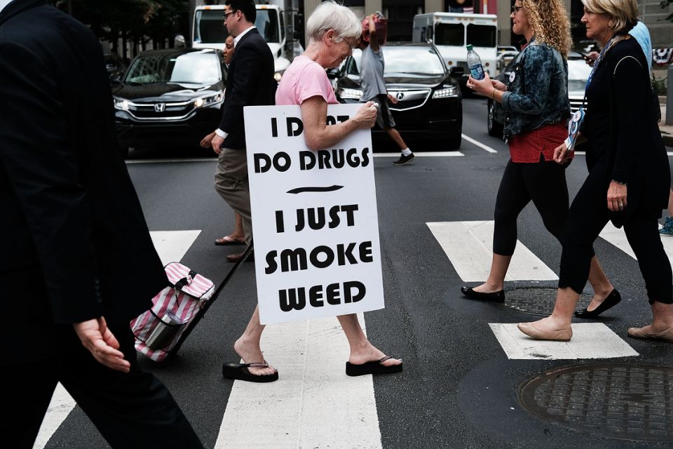 PHILADELPHIA, PA - JULY 28: A woman walks with a sign supporting the legalization of marijuana during the Democratic National Convention (DNC) on July 28, 2016 in Philadelphia, Pennsylvania.  The congress officially started on Monday and has drawn thousands of protesters, media representatives and democratic delegates to the city of brotherly love.  (Photo by Spencer Platt / Getty Images)