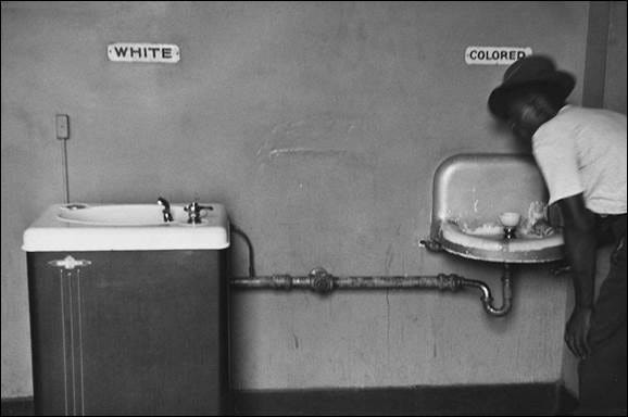 A photo by Elliott Erwitt shows separate drinking fountains.  The photo can be seen in