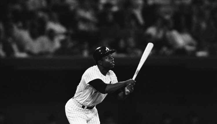 FILE - In this file photo dated April 27, 1971, Hank Aaron of the Atlanta Braves watches his 600th major league home game play during the third inning of a game against the San Francisco Giants.  Hank Aaron, who endured racist threats with stoic dignity during his pursuit of Babe Ruth but broke the career home run record in the pre-steroid era, died early Friday, January 22, 2021. He was 86 years old.  The Atlanta Braves said Aaron died peacefully in his sleep.  No cause of death was given.  (AP Photo / Jack Harris, File)