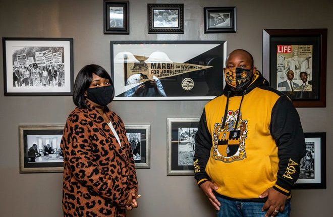 Aaron Pearl-Cropp and his wife Annie Brooks-Pearl pose with only some of the Martin Luther King Jr. and Civil Rights Movement memorabilia on display in their home, including an original pennant and button dated March 1963 in Washington, Thursday, March 14th January 2021 in Illinois, Pearl-Cropp became interested in memorabilia collecting three years ago after starting an internship at the Central Illinois African American History Museum as part of his master's degree. [Justin L. Fowler/The State Journal-Register]