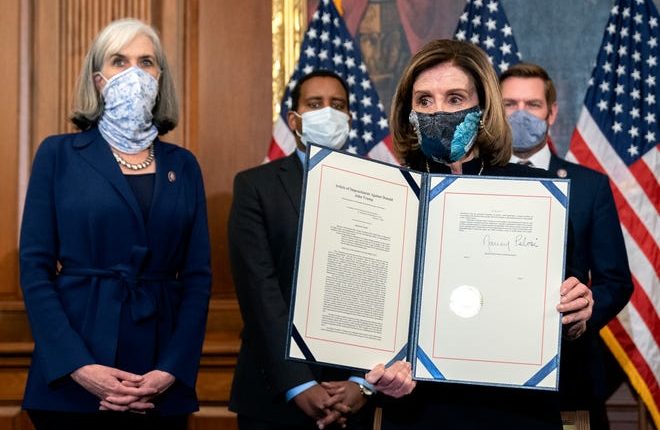 House Speaker Nancy Pelosi, D-Calif., displays a signed article of impeachment against President Donald Trump at the U.S. Capitol on Wednesday.