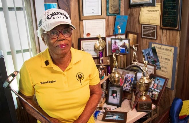 Victoria Kingdom, 92, poses with some of the many golf prizes and trophies she has at her Riviera Beach home.