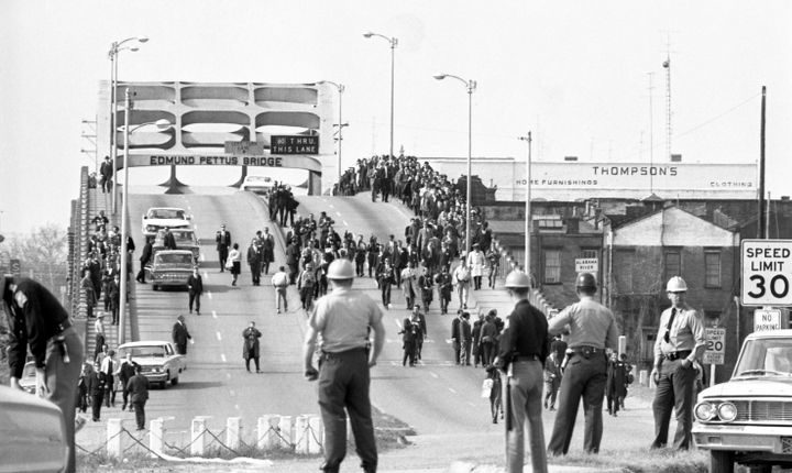State forces watch as protesters cross the Edmund Pettus Bridge over the Alabama River in Selma, Alabama as part of a civilian population 