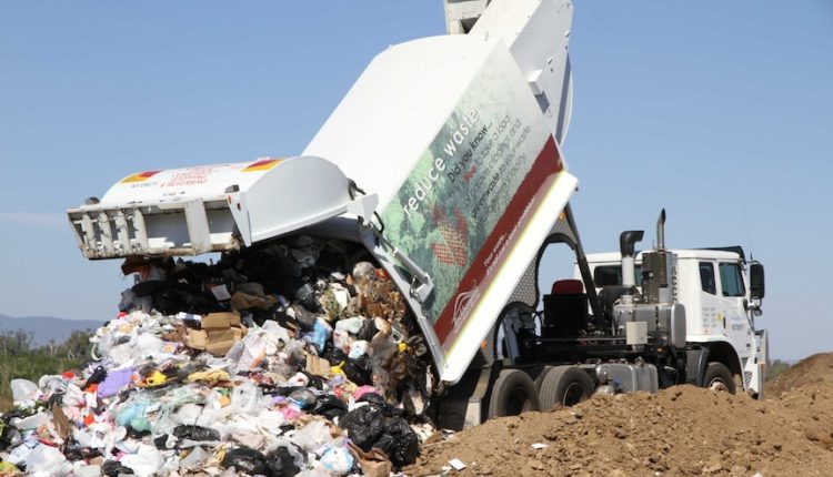 Garbage truck dumping garbage on landfill