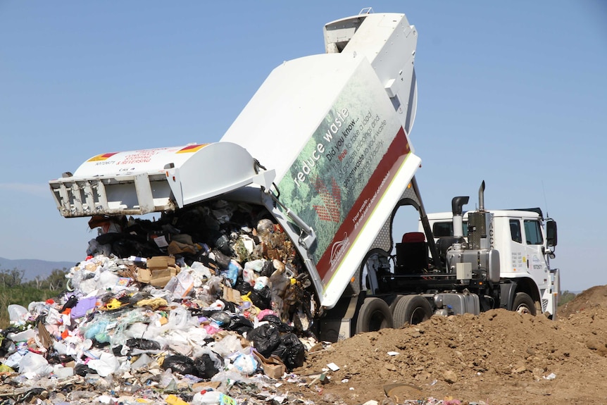 Garbage truck dumping garbage on landfill
