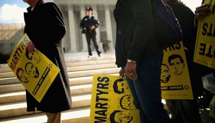 With signs with pictures of the murdered civil rights activists James Earl Chaney, Andrew Goodman and Michael 