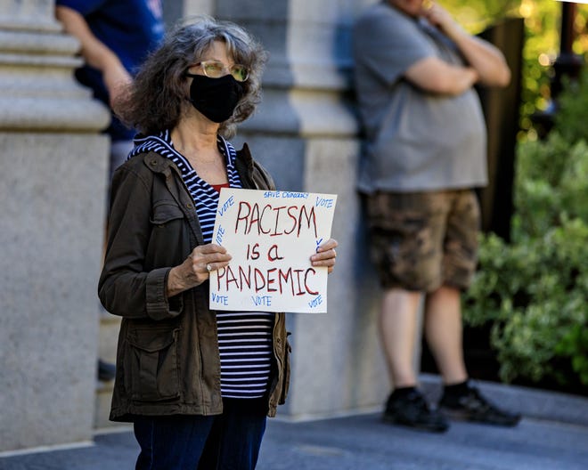 A protester holds a sign that reads