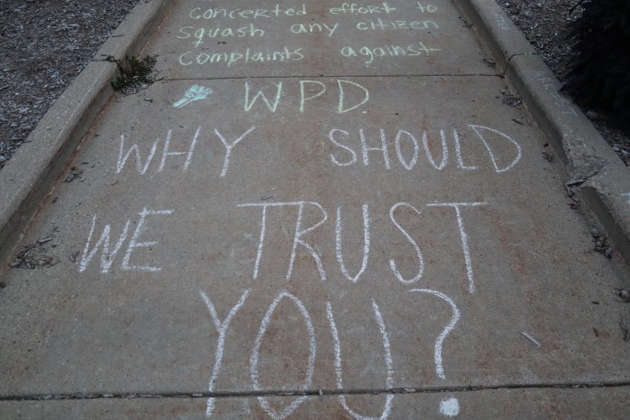Protesters marked the ground in front of Wauwatosa City Hall with chalk with various messages written on it.  (Photo | Isiah Holmes)