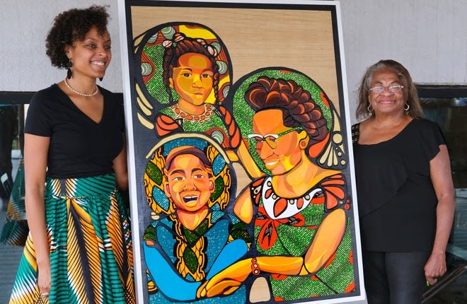 Artist Ebony Iman Dallas (left) and Marilyn Luper Hildreth, Clara Luper's daughter, pose next to a Luper of Dallas multimedia artwork commissioned by Citizen's Bank of Edmond during a unveiling Thursday morning.