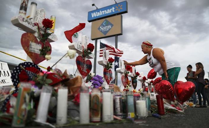 A woman touches a cross on a makeshift memorial to victims outside of Walmart, near the scene of a mass shooting in El Paso, Texas.  (Mario Tama / Getty Images)
