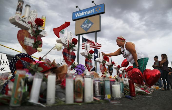A woman touches a cross on a makeshift memorial to victims outside of Walmart, near the scene of a mass shooting in El Paso, Texas.  (Mario Tama / Getty Images)